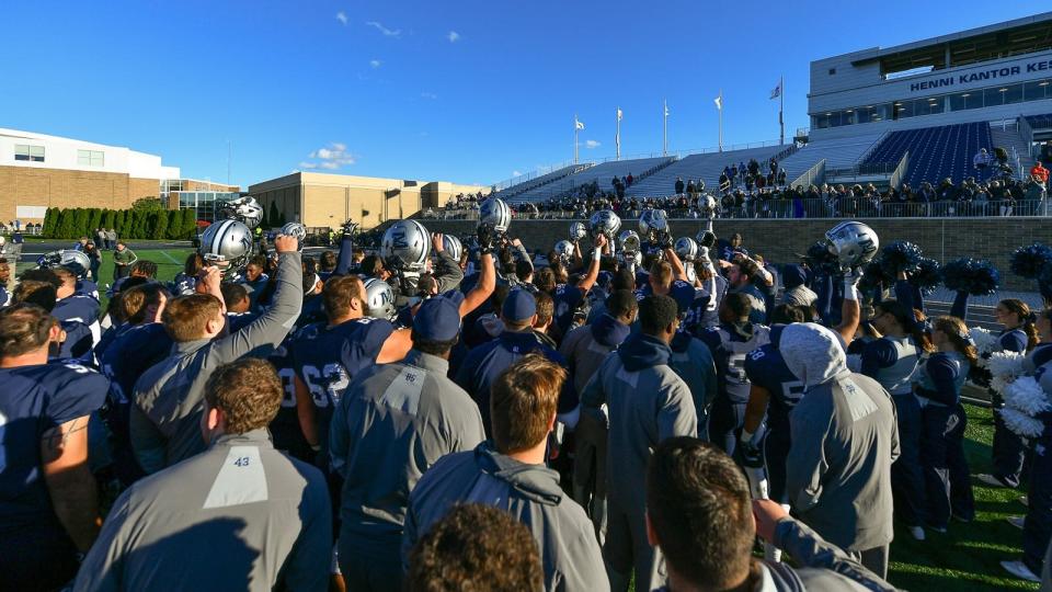 Monmouth players sing the school fight song after a 2018 victory at Kessler Stadium.