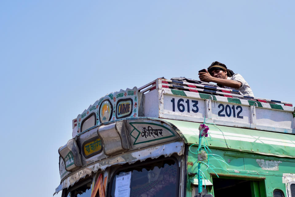 MUMBAI, MAHARASHTRA, INDIA - 2020/05/13: A man takes a selfie on top of the truck during the stranded situation. Due to lockdown situation, most migrants are stuck in Mumbai, some walk and others arrange their own trucks and buses to their home towns, while the police say that the buses are available by the government. (Photo by Ratika More/SOPA Images/LightRocket via Getty Images)