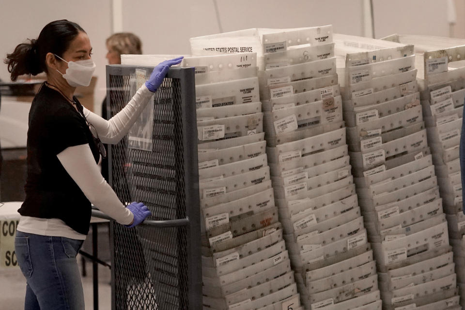 An election worker arrives with ballots to be tabulated inside the Maricopa County Recorders Office, Wednesday, Nov. 9, 2022, in Phoenix. (AP Photo/Matt York)