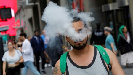 A man uses a vape as he walks on Broadway in New York City