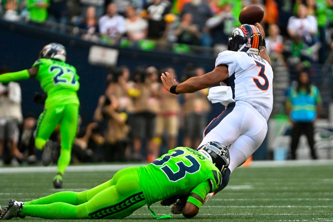 Denver Broncos quarterback Russell Wilson (3) gets a pass away before being tackled by Seattle Seahawks safety Jamal Adams (33) during the first quarter of an NFL game on Monday, Sept. 12, 2022, at Lumen Field in Seattle.