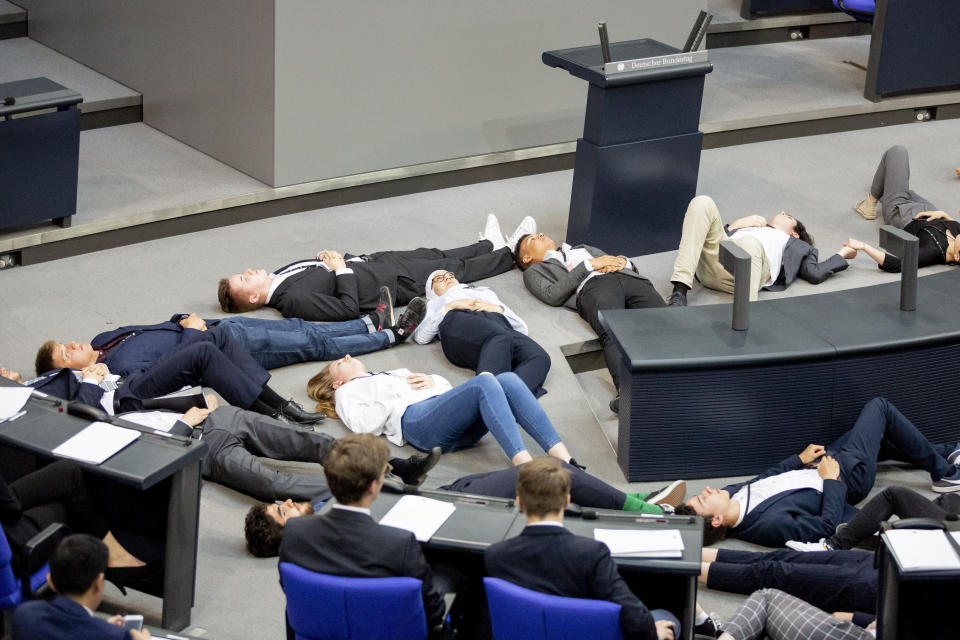 Participants of a protest action for climate justice by Fridays For Future lie on the floor in the plenary hall of the Bundestag in Berlin, Germany, Tuesday, June 4, 2019. In the simulation game "Youth and Parliament", young people slip into the role of members of the Bundestag. (Christoph Soeder/dpa via AP)