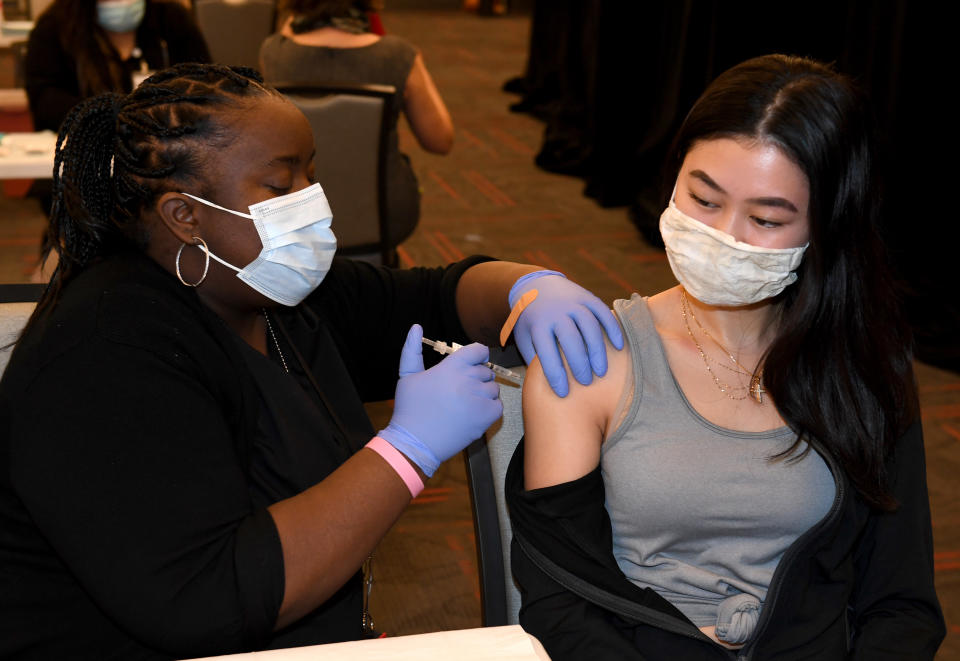 LAS VEGAS, NEVADA - JANUARY 12:  UNLV Medicine medical assistant Delicia Sullivan (L) administers a Pfizer-BioNTech COVID-19 vaccination to UNLV School of Nursing student Arianna Nicole at UNLV on January 12, 2021 in Las Vegas, Nevada. UNLV officials established the vaccination center on campus yesterday and plan to open another one next week at College of Southern Nevada in Henderson, Nevada, to distribute about 1,000 doses a week at each location to the Nevada System of Higher Education (NSHE) schools. The first vaccinations are going to front-line health care staff, including members of the UNLV medical, dental and nursing schools, people who see patients and university police officers. After that, plans are to vaccinate employees who work on campus, remaining NSHE staff and students living in on-campus housing, followed by the remaining student body and possibly the public.  (Photo by Ethan Miller/Getty Images)