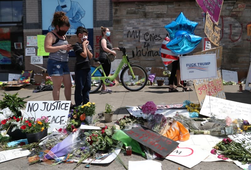 People gather at a memorial for George Floyd at the place where he was taken into police custody and later died in Minneapolis