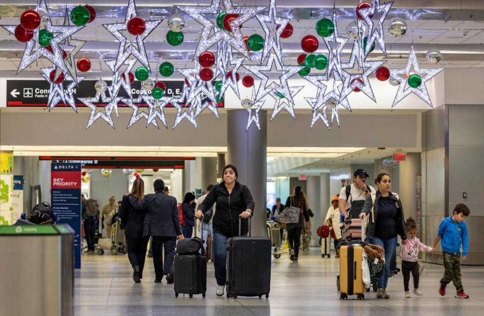 Miami, Florida, 16 de noviembre de 2023 - Pasajeros caminan bajo las decoraciones navideñas en el Aeropuerto Internacional de Miami.