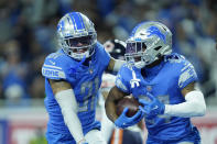 Detroit Lions cornerback Amani Oruwariye, right, celebrates an interception with teammate safety Dean Marlowe during the second half of an NFL football game, Thursday, Nov. 25, 2021, in Detroit. (AP Photo/Paul Sancya)