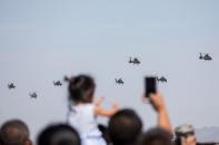 <p>Spectators take photos as helicopters perform during the opening ceremony of three games hosted by Chinese People’s Liberation Army (PLA), part of International Army Games 2018 in Korla, Xinjiang Uighur Autonomous Region, China, July 29, 2018. (Photo: Stringer/Reuters) </p>