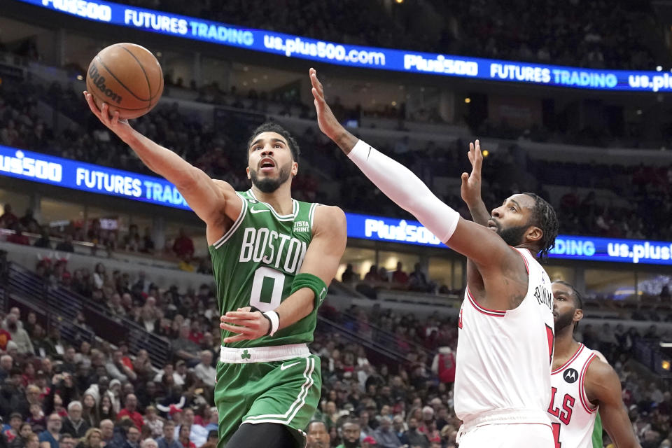 Boston Celtics' Jayson Tatum drives to the basket past Chicago Bulls' Andre Drummond during the first half of an NBA basketball game Monday, Nov. 21, 2022, in Chicago. (AP Photo/Charles Rex Arbogast)