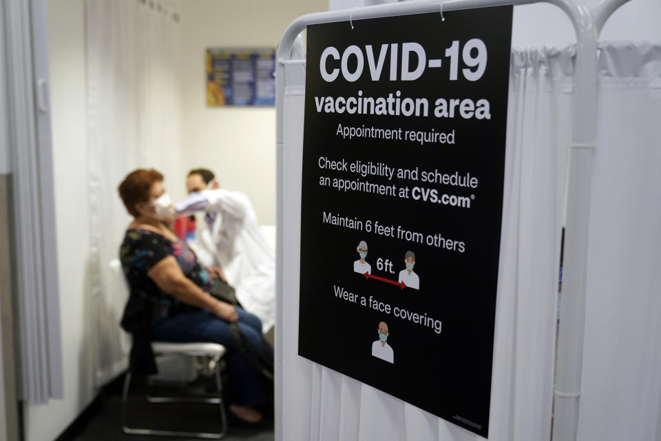 FILE - In this March 1, 2021, file photo, a patient receives a shot of the Moderna COVID-19 vaccine next to a guidelines sign at a CVS Pharmacy branch in Los Angeles. More than 27 million Americans fully vaccinated against the coronavirus will have to keep waiting for guidance from U.S. health officials for what they should and shouldn’t do. The Biden administration said Friday, March 5, it’s focused on getting the guidance right and accommodating emerging science. (AP Photo/Marcio Jose Sanchez, File)