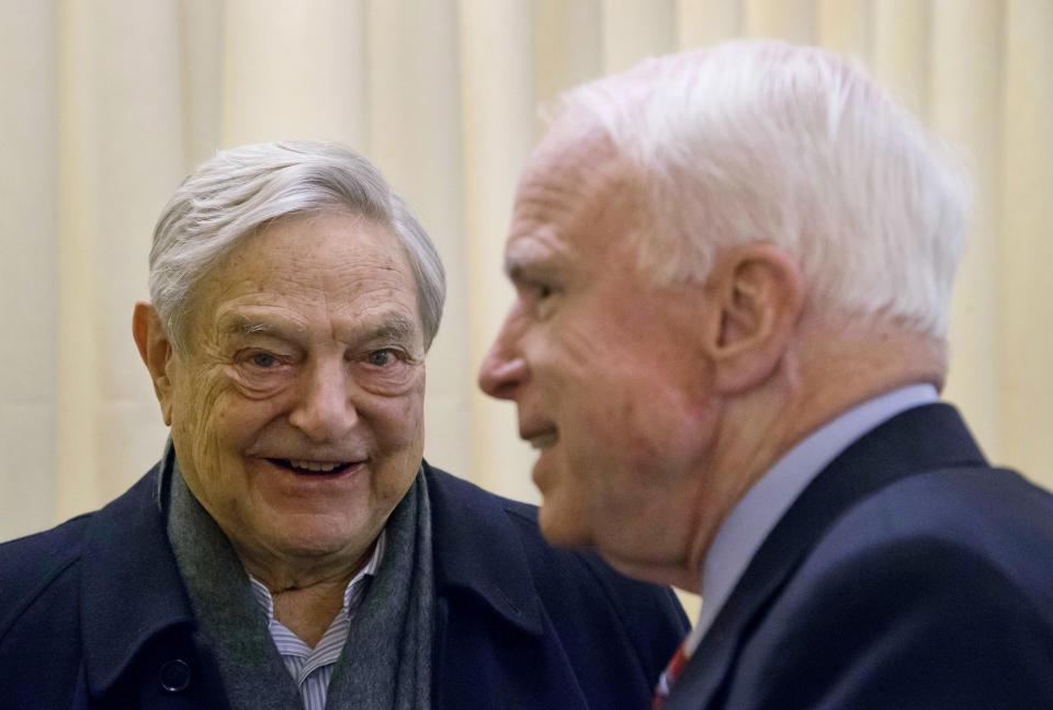 FILE - In this Thursday, Jan. 23, 2014 file photo, Chairman of Soros Fund Management George Soros, left, talks with U.S. Sen. John McCain, R-Ariz., during the World Economic Forum in Davos, Switzerland. The mail bomb that showed up in the mail box of billionaire investor and philanthropist George Soros on Oct. 22, 2018 is a reminder of his place as one of the far right’s most hated boogeymen. (AP Photo/Michel Euler)