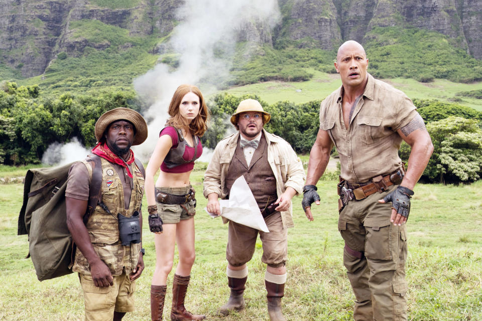 Kevin Hart, Karen Gillan, Jack Black, and Dwayne Johnson stand in a grassy field