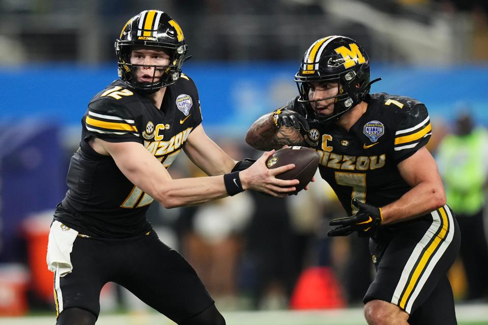 Dec 29, 2023; Arlington, Texas, USA; Missouri Tigers quarterback Brady Cook (12) hands off to running back Cody Schrader (7) during the fourth quarter of the Goodyear Cotton Bowl Classic against the Ohio State Buckeyes at AT&T Stadium. Ohio State lost 14-3.