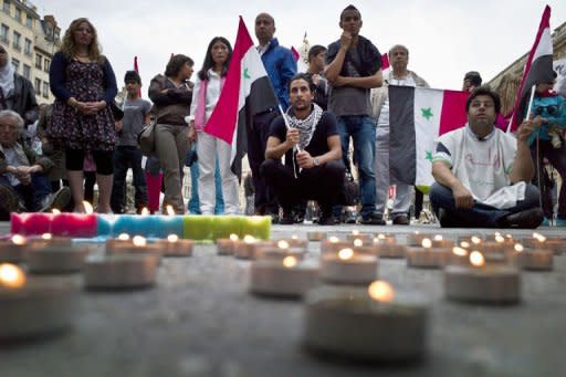 People demonstrate with Syrian national flags and candles in front of Lyon city hall, France. Hundreds of Syrian dissidents debated strategies to oust Bashar al-Assad's regime Saturday in Istanbul as US Secretary of State Hillary Clinton called for a halt to the "brutal" repression of protests