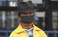 A man, wearing protective face masks as a precaution against the spread of the new coronavirus, waits in a bus line in Quito, Ecuador, Wednesday, June 3, 2020. After 80 days of an almost complete shutdown, the capital city lowers its warning alert from red to yellow allowing for the freer movement of people and the opening of many businesses. (AP Photo/Dolores Ochoa)