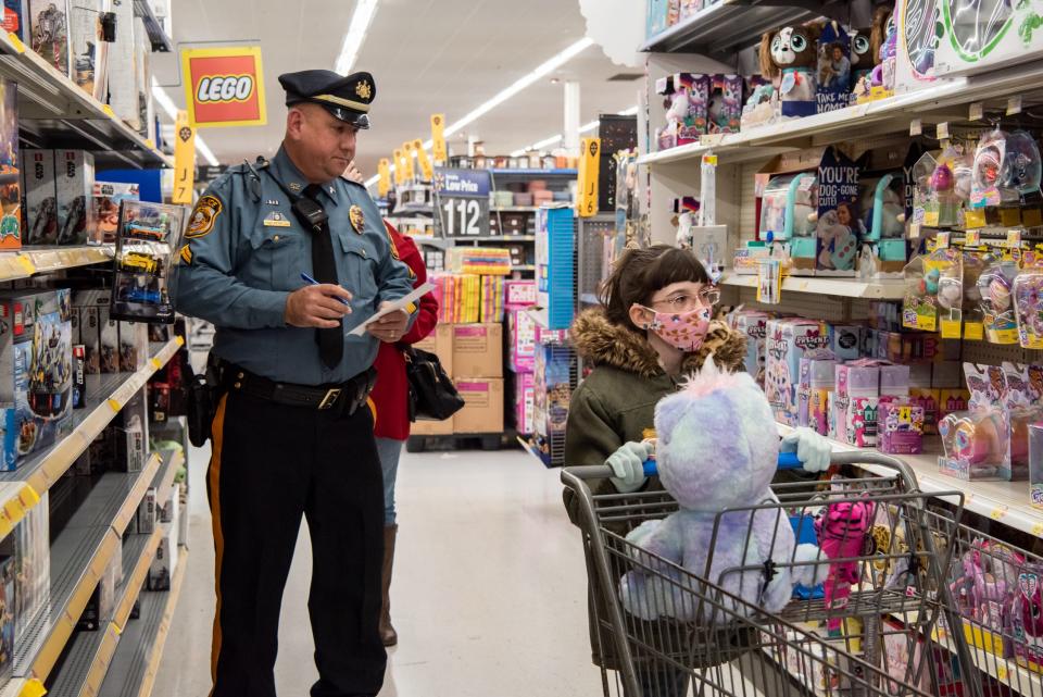 Newtown Township Police Cpl. Paul Deppi, left, and Kaylee Holtzman, 10, of Doylestown browse the toy aisles during Plumstead Township Police Department's 5th annual Shop with a Cop event at Walmart in Hilltown Township on Tuesday, December 8, 2021. Funded by community donations, the program paired law enforcement officers from 11 local departments with more than 100 kids to help them shop for presents for themselves and their families.