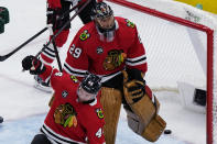 Chicago Blackhawks goaltender Marc-Andre Fleury, top, and defenseman Calvin de Haan react after Minnesota Wild left wing Marcus Foligno scored a goal during the first period of an NHL hockey game in Chicago, Friday, Jan. 21, 2022. (AP Photo/Nam Y. Huh)