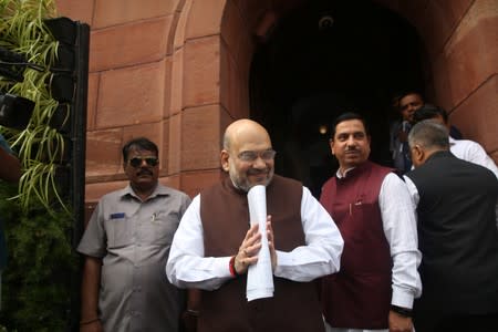 India's Home Minister Amit Shah greets the media upon his arrival at the parliament in New Delhi