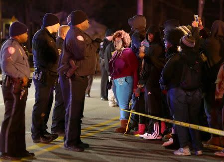 Protesters yell at police protecting the perimeter of a scene where a teenager was fatally shot by a police officer earlier at a Mobil gas station on North Hanley Road in Berkeley, Missouri, December, 24, 2014. REUTERS/David Carson/St. Louis Post-Dispatch/TNS