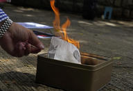 A pro-China supporter burns a picture of U.S. President Donald Trump during a protest against the U.S. sanctions outside the U.S. Consulate in Hong Kong Saturday, Aug. 8, 2020. The U.S. on Friday imposed sanctions on Hong Kong officials, including the pro-China leader of the government, accusing them of cooperating with Beijing's effort to undermine autonomy and crack down on freedom in the former British colony. (AP Photo/Vincent Yu)