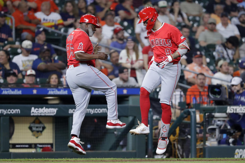 Los Angeles Angels third base coach Eric Young Sr., left, and Zach Neto (9) celebrate after a solo home run by Neto who rounds the bases during the sixth inning of a baseball game against the Houston Astros, Monday, May 20, 2024, in Houston. (AP Photo/Michael Wyke)