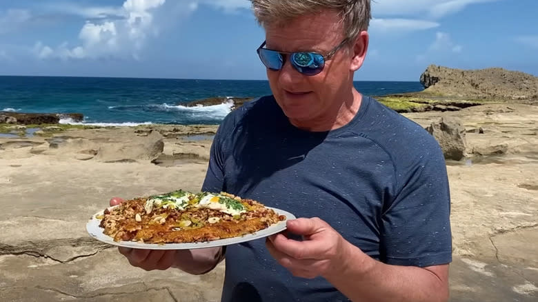 Gordon Ramsay holds a plate of pegao 