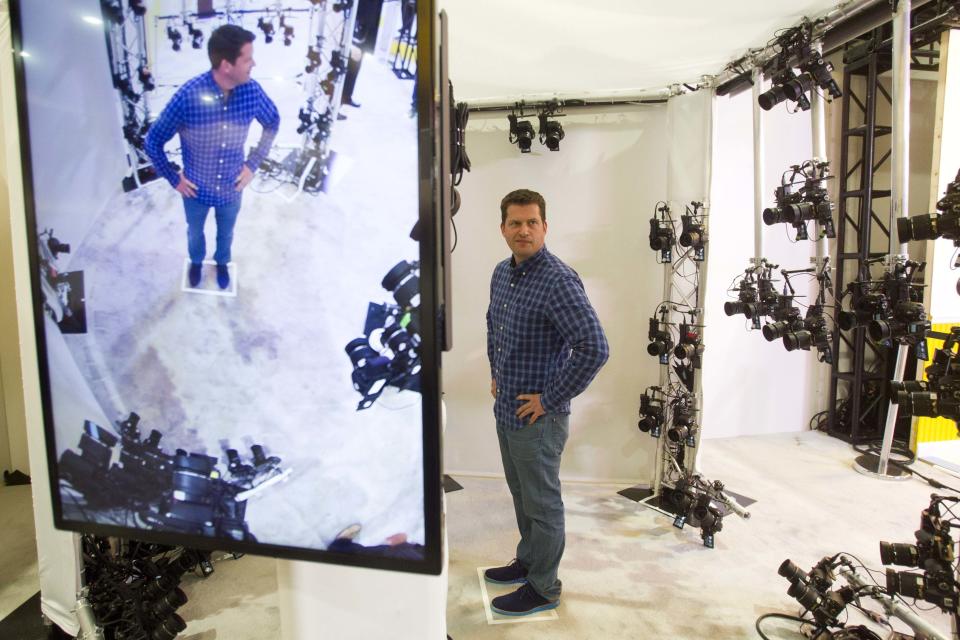 Show attendee Limore Shur waits inside a Nikon-powered XXArray during the 2014 International Consumer Electronics Show (CES) in Las Vegas, Nevada, January 7, 2014. The booth uses 68 cameras that fire at the same time. The images are processed to create a 3D model of the subject that can be placed inside a computer video game. REUTERS/Steve Marcus (UNITED STATES - Tags: BUSINESS SCIENCE TECHNOLOGY TPX IMAGES OF THE DAY)