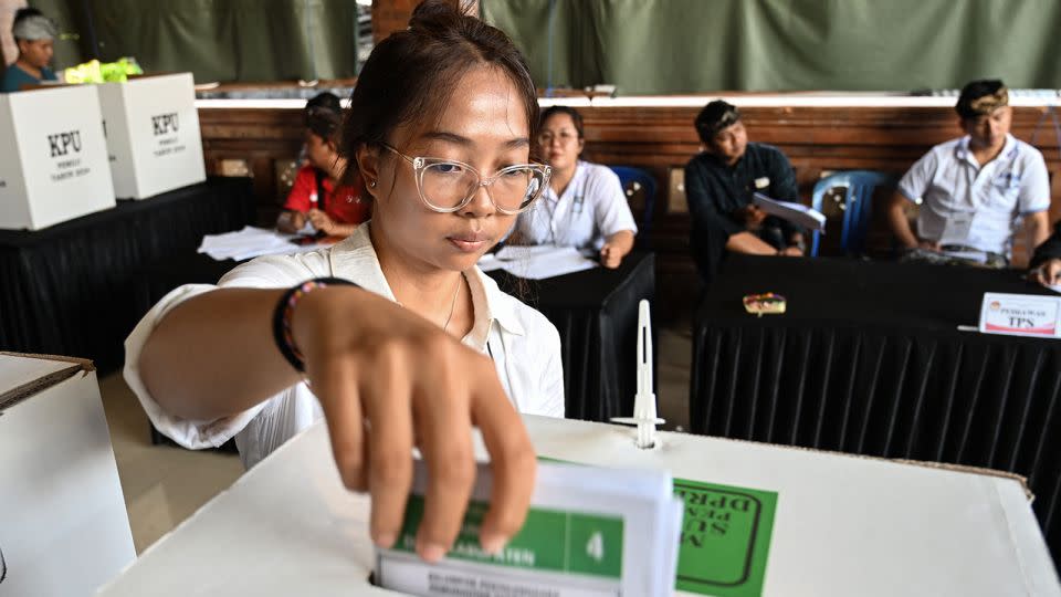 A woman casts her ballot in Banjar Teba, Jimbaran on the resort island of Bali on February 14, 2024. - Sonny Tumbelaka/AFP/Getty Images