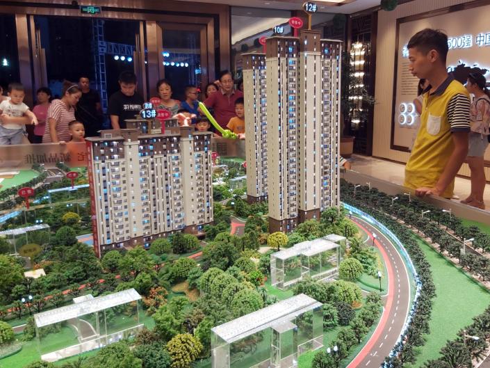 People look at model of real estate property at a showroom of Country Garden on August 25, 2019 in Yichang, Hubei Province of China.