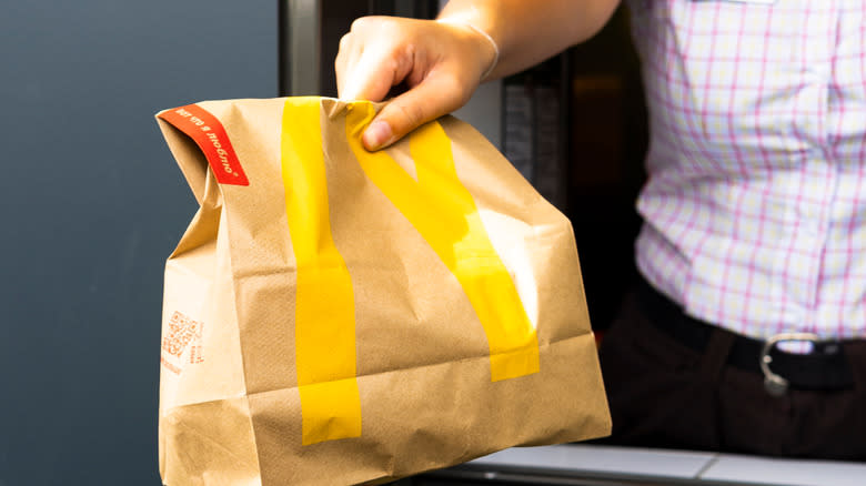 McDonald's employee handing bag to customer