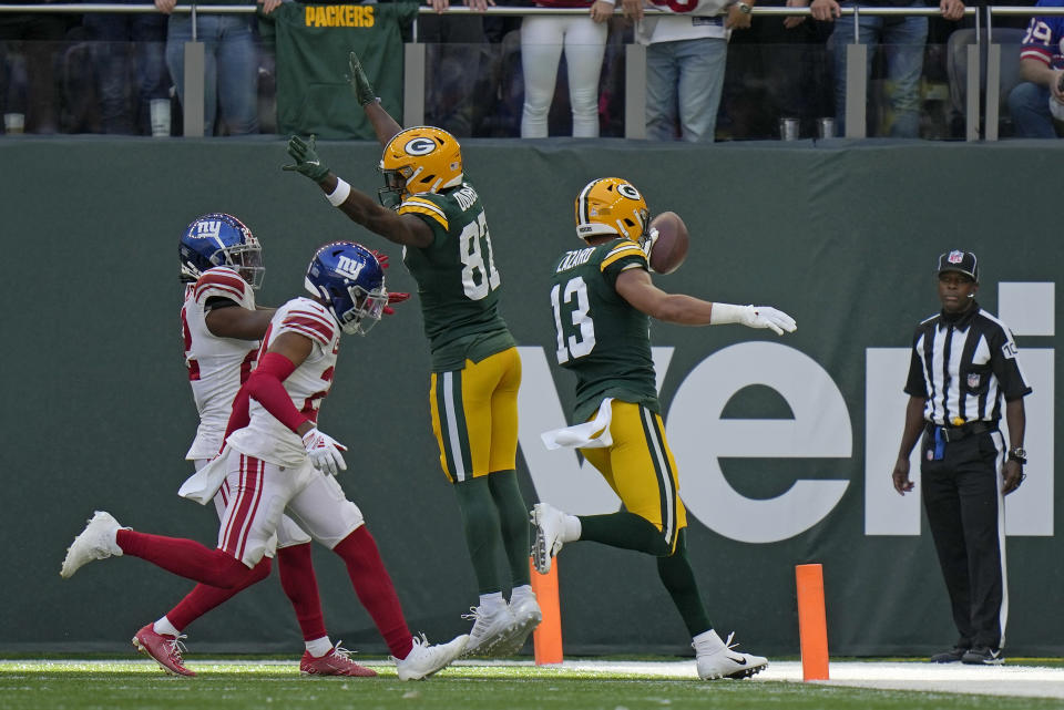 Green Bay Packers wide receiver Allen Lazard (13), right, celebrates after scoring a touchdown during an NFL game between the New York Giants and the Green Bay Packers at the Tottenham Hotspur stadium in London, Sunday, Oct. 9, 2022. (AP Photo/Alastair Grant)