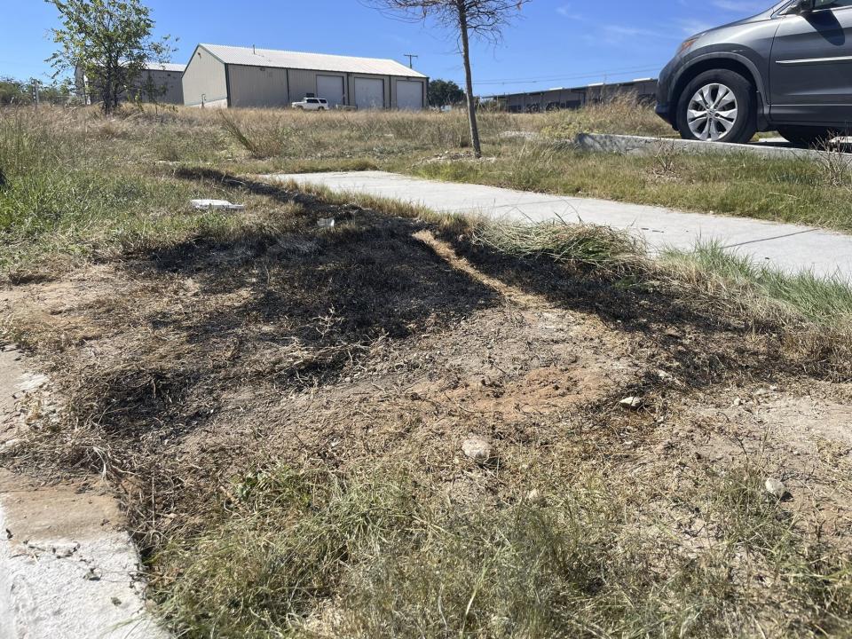 This Sept. 24, 2021 photo provided by Jason Allen and KTVT, shows the spot in Fort Worth, Texas, where a dumpster was on fire that had dismembered bodies inside. Police said the bodies appeared to be those of a man, a teen girl or adult woman, and a child. As of Monday, Sept. 27, 2021, authorities had identified only the man. Police have said the identification process has been difficult because of the condition of the bodies. (Jason Allen/KTVT via AP)