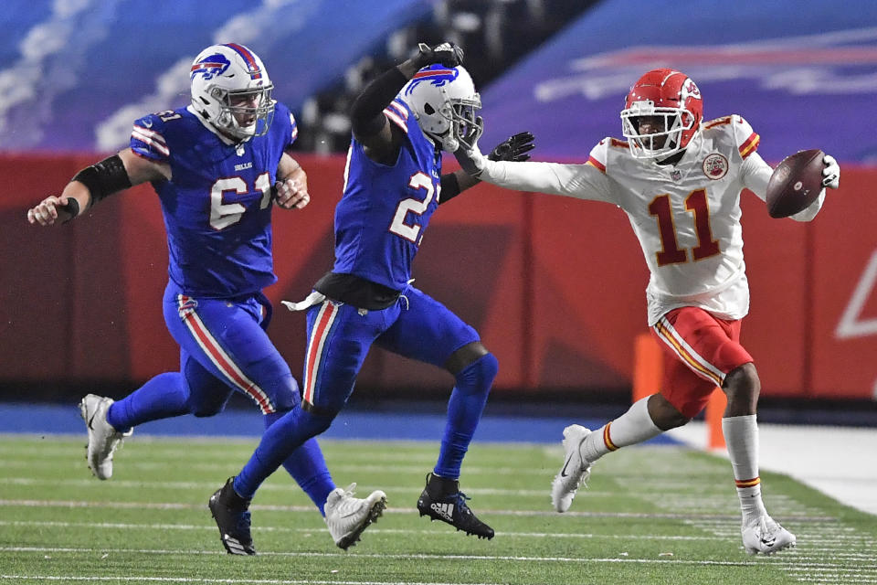 Kansas City Chiefs' Demarcus Robinson (11) holds off Buffalo Bills' Tre'Davious White (27) as Bills' Justin Zimmer (61) also pursues during the second half of an NFL football game, Monday, Oct. 19, 2020, in Orchard Park, N.Y. (AP Photo/Adrian Kraus)