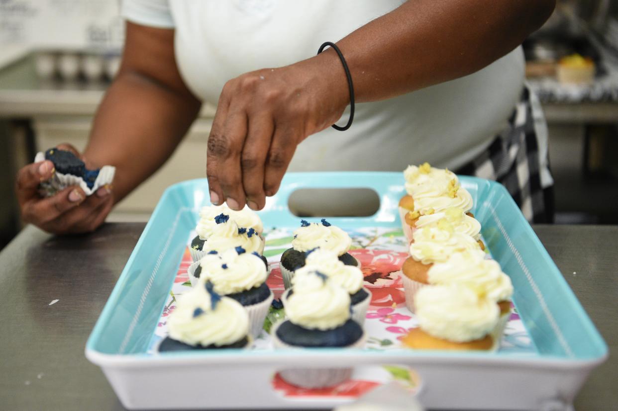 Chandra Taylor, owner of Mer Mer’s Bakery on North Gay Street, decorates cupcakes.