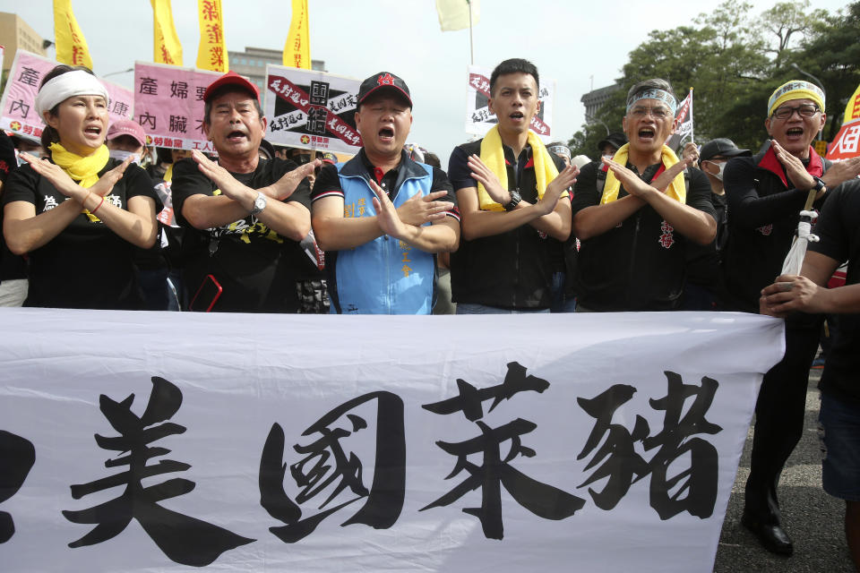 People shout slogans with a banner reading "U.S. ractopamine pork" during a protest in Taipei, Taiwan, Sunday, Nov. 22. 2020. Thousands of people marched in streets on Sunday demanding the reversal of a decision to allow U.S. pork imports into Taiwan, alleging food safety issues. (AP Photo/Chiang Ying-ying)