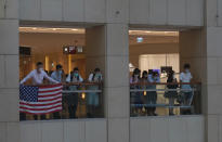 Protesters displays a U.S. flag in a shopping mall during a protest against China's national security legislation for the city, in Hong Kong, Monday, June 1, 2020. The mouthpiece of China's ruling Communist Party says U.S. moves to end some trading privileges extended to Hong Kong grossly interfere in China's internal affairs and are doomed to fail. (AP Photo/Vincent Yu)