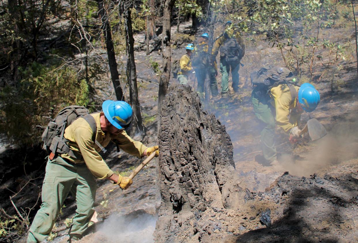 Crew members from Angeles National Forest mop up in the McKinney Fire burn area.