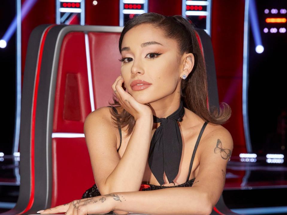 ariana grande posing for a photo in a coach chair on the voice