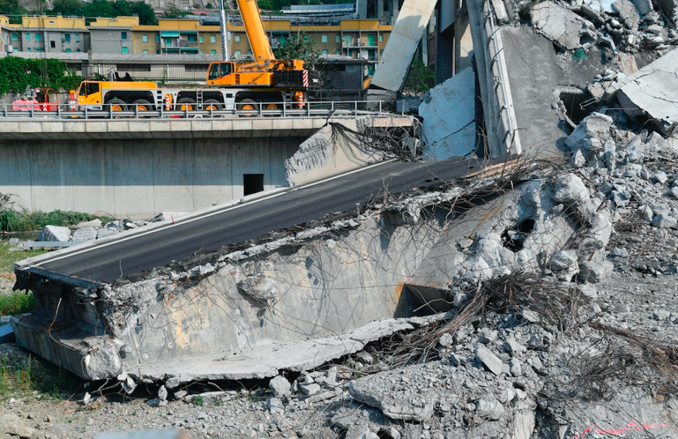 <em>Work is continuing to clear tonnes of bridge debris that cascaded onto a dry riverbed below (AP)</em>