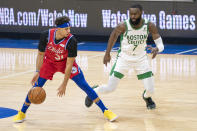 Philadelphia 76ers' Seth Curry, left, looks to make his move against Boston Celtics' Jaylen Brown, right, during the first half of an NBA basketball game, Friday, Jan. 22, 2021, in Philadelphia. (AP Photo/Chris Szagola)