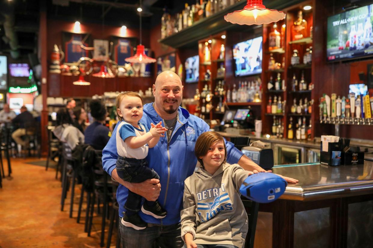 Steve Mallie, 55, holds his 1-year-old son Parker, standing next to his other son Gavin Mallie, 11, all of Trenton, at his bar Mallie’s Sports Grill and Bar in Southgate, Mich. on Friday, Jan. 5, 2024.