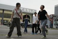 Young Chinese walk past a Tesla showroom in Beijing, Tuesday, May 30, 2023. China’s foreign minister met Tesla Ltd. CEO Elon Musk on Tuesday and said strained U.S.-Chinese relations require “mutual respect,” while delivering a message of reassurance that foreign companies are welcome. (AP Photo/Ng Han Guan)