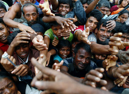 Rohingya refugees stretch their hands to receive aid distributed by local organisations at a makeshift camp in Cox's Bazar, Bangladesh September 18, 2017. REUTERS/Danish Siddiqui