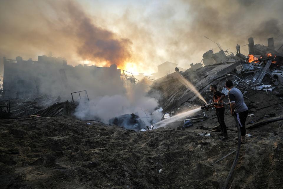 Palestinians try to put out a fire amid search for survivors (EPA)