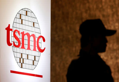 A security personnel stands near the logo of Taiwan Semiconductor Manufacturing Co. Ltd (TSMC) during an investor conference in Taipei, July 16, 2014. REUTERS/Pichi Chuang/File Photo