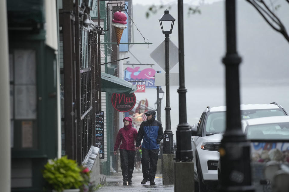 Visitors stroll by tourist shops in the rain during storm Lee, Saturday, Sept. 16, 2023, in Bar Harbor, Maine. Severe conditions were predicted across parts of Massachusetts and Maine, and hurricane conditions could hit the Canadian provinces of New Brunswick and Nova Scotia, where the storm, Lee, downgraded early Saturday from hurricane to post-tropical cyclone, was expected to make landfall later in the day. (AP Photo/Robert F. Bukaty)