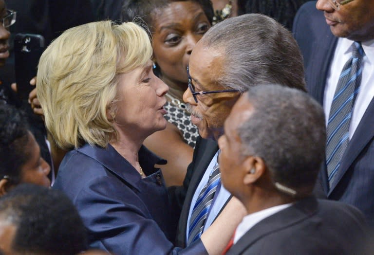 Former secretary of state and presidential hopeful Hillary Clinton (L) hugs civil rights activist Al Sharpton during the funeral of Rev. and South Carolina State Sen. Clementa Pinckney in Charleston, South Carolina on June 26, 2015