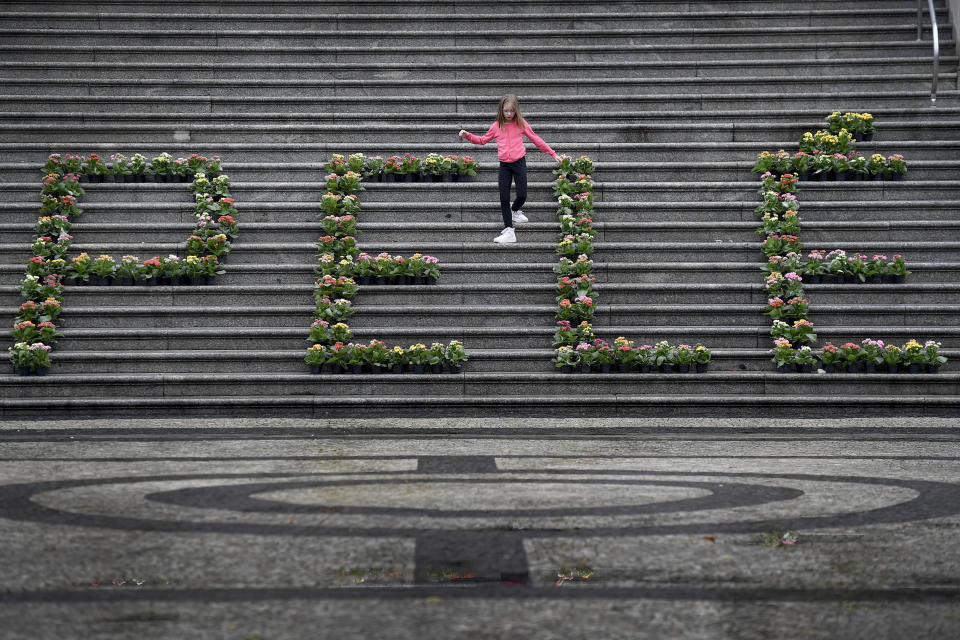 A girl walks among a floral arrangement for the late Brazilian soccer star Pele at the City Hall in Santos, Brazil, Friday, Dec. 30, 2022. Pele, who played most of his career with Santos FC, died in Sao Paulo Thursday at the age of 82. (AP Photo/Matias Delacroix)