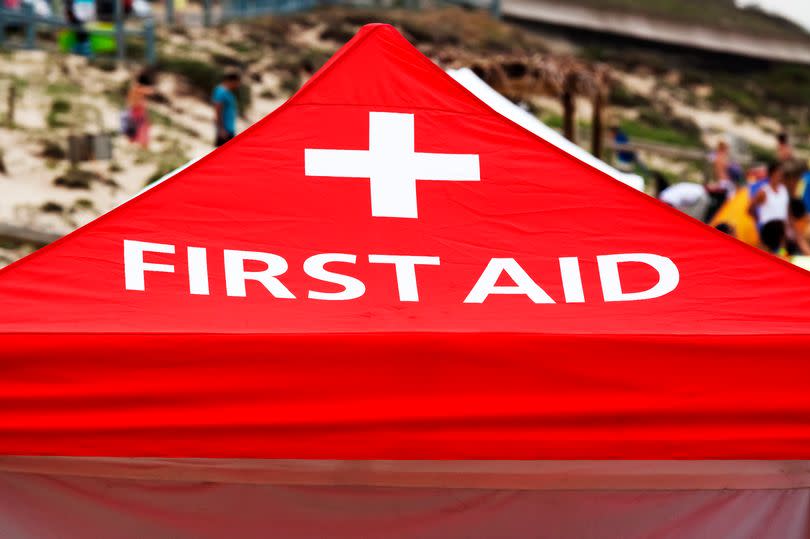 Closeup sign "First aid" on red tent with white cross, full frame horizontal composition