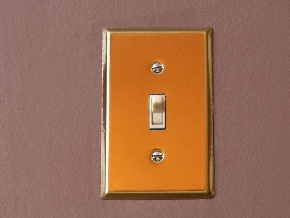 A light switch with a gold cover