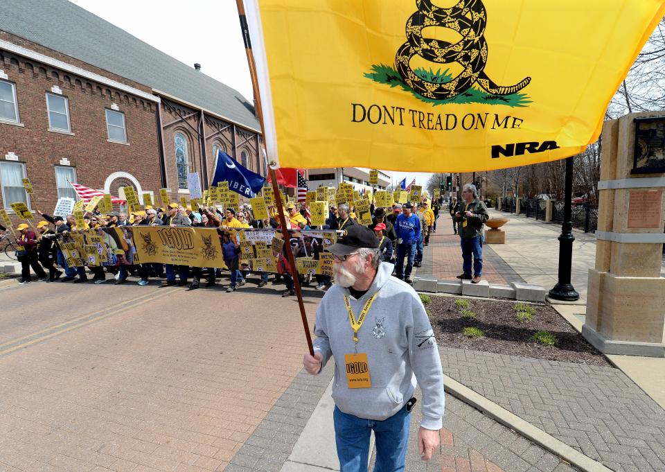 Jerry Ambrose, of Palmyra, right, carries a NRA Don't Tread on Me flag as he marches to the state Capitol during Illinois Gun Owner Lobby Day Wednesday, March, 29, 2023.